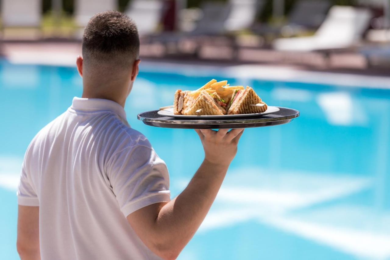 Hotel Du Lac Congress Center & Spa Ioannina Exterior foto A waiter serving food
